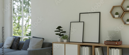 Blank frame mockups and a vintage vinyl record player on a wooden cabinet in a living room.