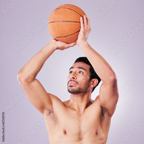 Fitness, basketball and a sports asian man shooting in studio on a gray background for training or a game. Exercise, body or aim and a shirtless young male athlete holding a ball during a competition