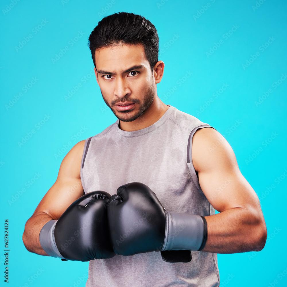 Portrait, man and fighter training, boxing or challenge on a blue studio background. Male person, Asian boxer or athlete with power, strong or serious face with workout, fight or wellness with sports
