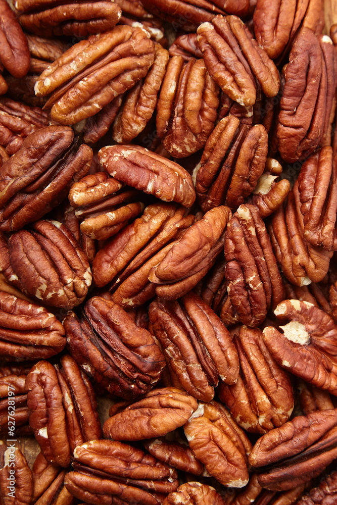 Pecan nuts texture background. Heap of pecan halves top view. Peeled pecan nuts