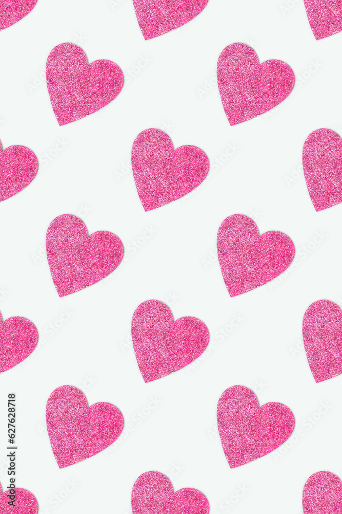 Repetitive pattern made of pink glittering hearts. Creative composition on a blue background.