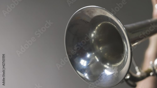 Slow motion video of a silver plated trumpet bell moving about while the instrument is being played