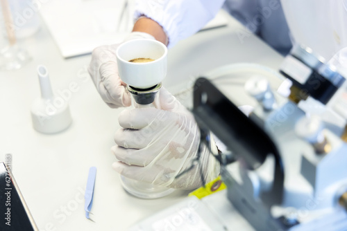 Hand holding flask with suction filtering flask using for analysis total suspended solids in wastewater, precipitate the sludge from water treatment system.