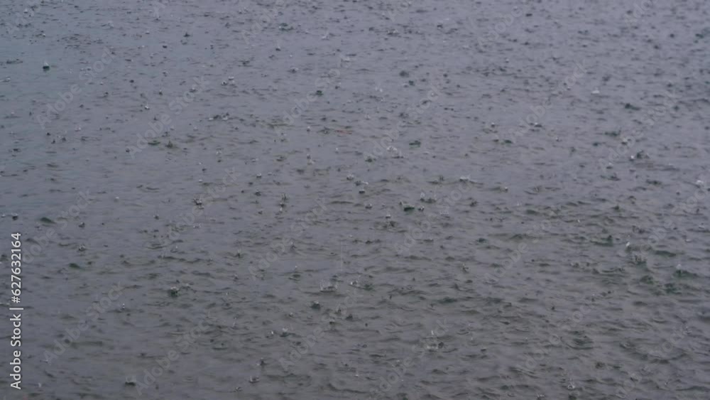 Details or hard storm rain on water surface. Raining on the lake.