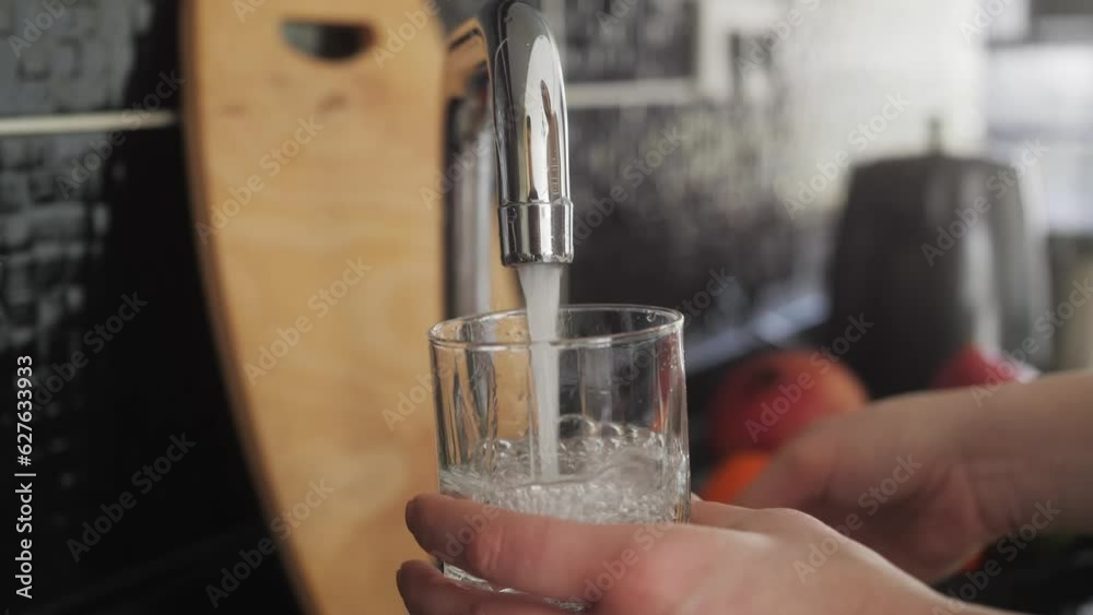 Woman pouring a tap water in glass, concept of pure drinking water.