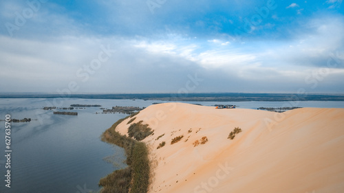 A sand dune with lake in background. An image from Yellow Lake  Saudi Arabia.