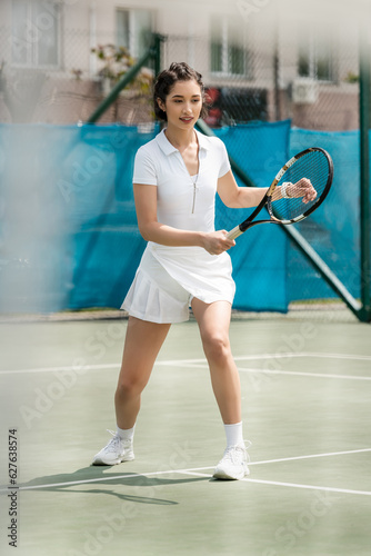 happy female player in sporty dress holding racket on tennis court,  summer sport, hobby and health © LIGHTFIELD STUDIOS