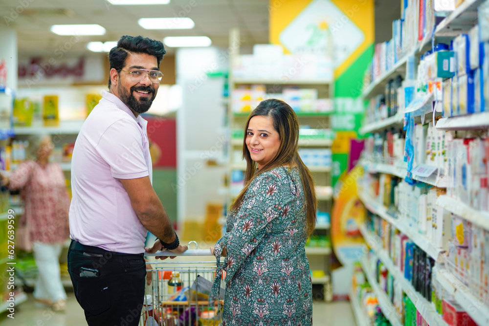 Young indian couple doing shopping together at grocery shop.