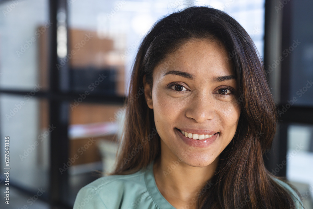Portrait of happy biracial casual businesswoman with long hair in office Portrait of happy biracial casual businesswoman with long hair in office