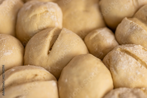Close up of cut dough for rolls with flour in bakery kitchen