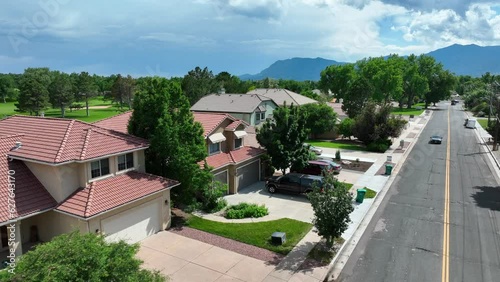 Luxurious retirement homes on golf course country club in Colorado Springs, CO. Aerial establishing shot with mountain range in distance.