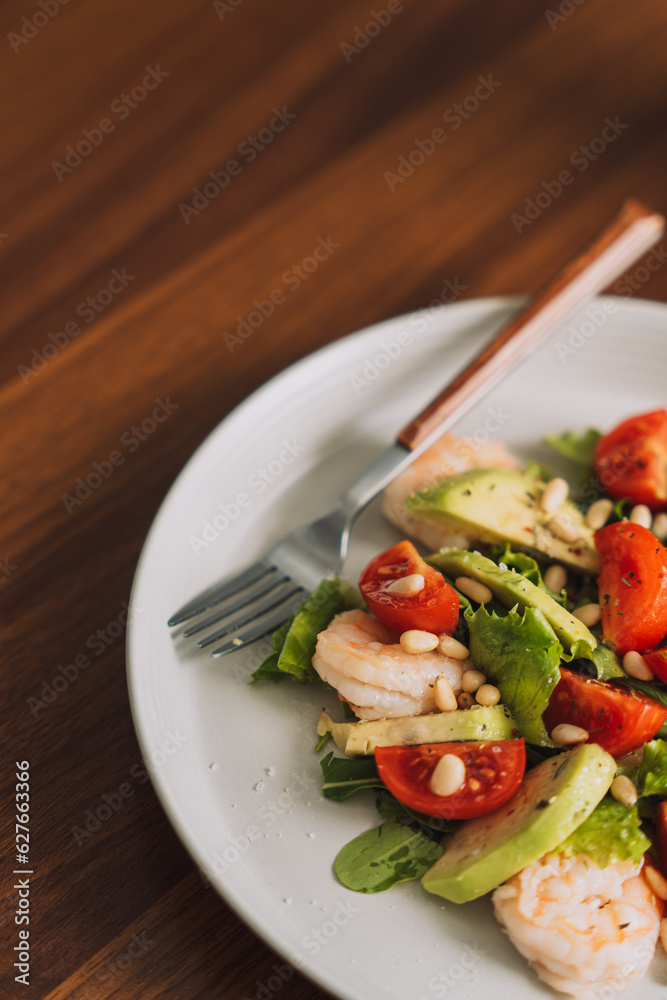 Vegetable salad with nuts on a white plate with a cup of coffee. Vegetable salad with nuts on a white plate with a cup of coffee.