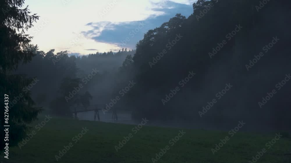 Foggy Evening Nature in Green Summer Scenic Countryside. Landscape of Moody Sunsete White Mist. Fog Crawls Over Meadow With Green Grass Misty Evening in Field Tervete National Park in Latvia Foggy Evening Nature in Green Summer Scenic Countryside. Landscape of Moody Sunsete White Mist. Fog Crawls Over Meadow With Green Grass Misty Evening in Field Tervete National Park in Latvia