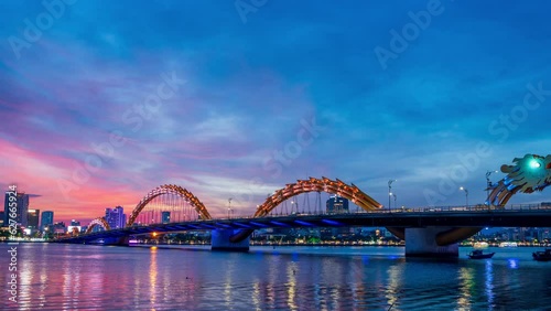 Zoom out, Day to night  Time-lapse of Dragon Bridge and traffic in Da Nang Vietnam photo