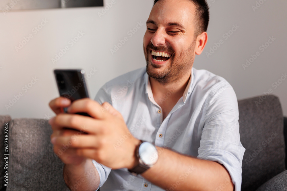 Man using smart phone while relaxing at home Man using smart phone while relaxing at home