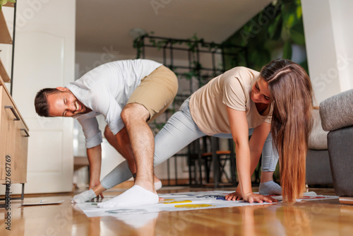 Fotografi Couple having fun playing balance keeping game at home