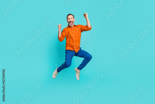 Full size body photo of crazy businessman jumper winner success achievement fists up triumphant isolated on aquamarine color background