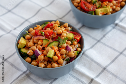 Homemade Avocado Chickpea Salad with Chili Lime Dressing in Bowls, side view. .