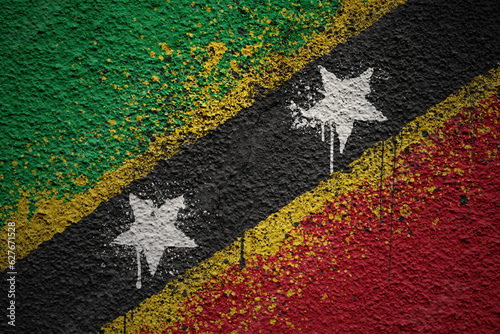 painted big national flag of saint kitts and nevis on a massive old cracked wall