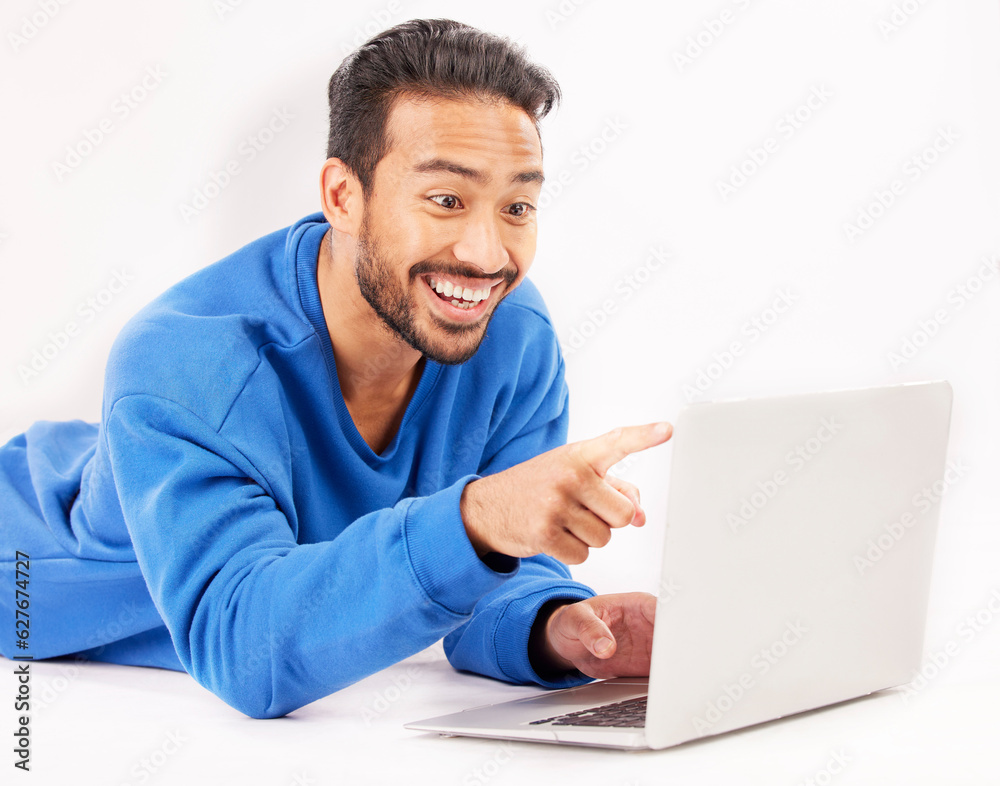 Surprise, laptop and man pointing on studio floor isolated on a white background. Computer, happy and person on ground for social media, streaming movie or film, video or show on internet with tech Surprise, laptop and man pointing on studio floor isolated on a white background. Computer, happy and person on ground for social media, streaming movie or film, video or show on internet with tech