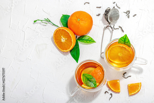 Orange tea in glass cups with ripe fruits. Refreshment seasonal drink, conceptual background