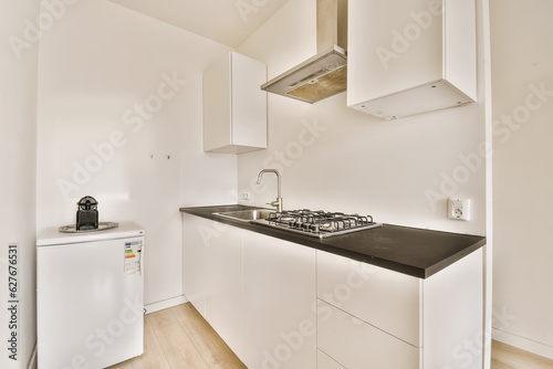 a kitchen area with white cabinets and black counter tops on the counters in this apartment is very well equipped for entertaining