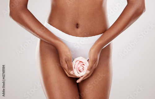 Woman, rose and hands with feminine hygiene and natural beauty in a studio. Body wellness, flower and model with white background and gynecology health with clean and eco friendly self care treatment