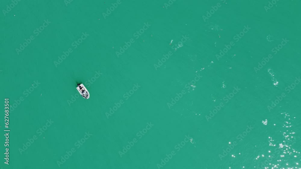 Fisherman on boat trying to catch kahawai fish feeding on the surface of the ocean in New Zealand Fisherman on boat trying to catch kahawai fish feeding on the surface of the ocean in New Zealand