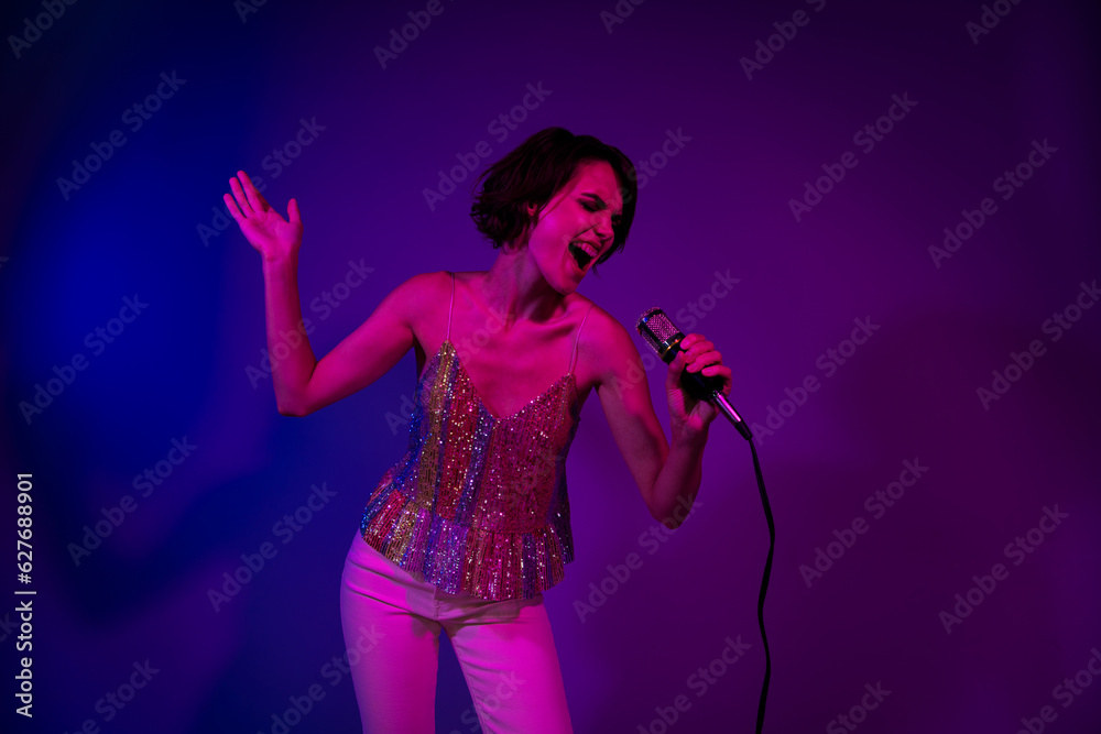 Photo of excited rock pop singer lady singing mic crazy songs on event occasion isolated neon colorful background