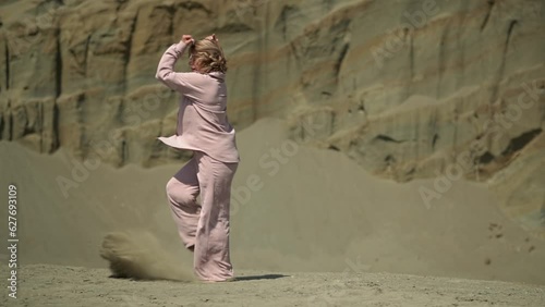woman dancing in the desert.slow motion video. a woman in casual clothes is dancing. High quality Full HD video recording photo