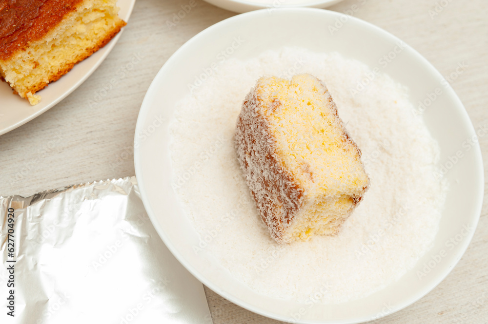 Delicious and Traditional Brazilian dessert known as BOLO GELADO - Making step by step: Cake in bowl with grated coconut