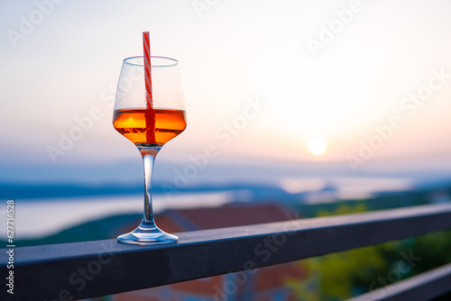 glass with a drink on vacation at sunset. Relax in the apartment © Kamil