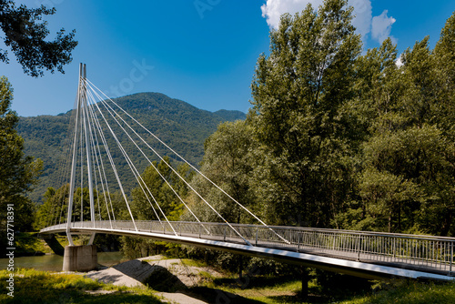 Modern pedestrian bridge in the middle of the mountains of Italian Switzerland, allowing you to cross the Ticino River.