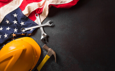 Happy Labor day concept. American flag with different construction tools on dark background.