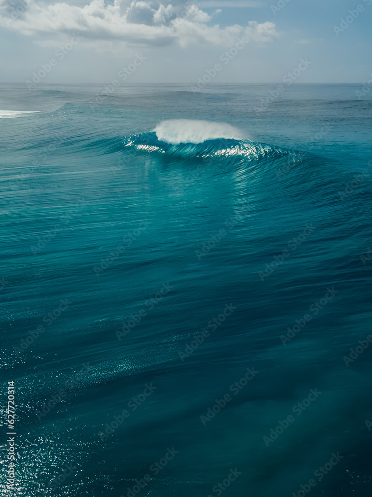Naklejka premium Glassy wave with barrel in blue ocean in Bali. Aerial view