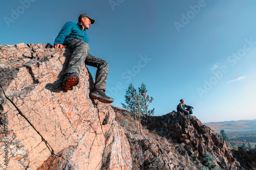 elderly man tourist sees off the sunset in the Ural mountains on an autumn day