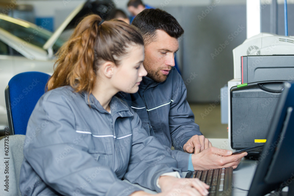 woman and man mechanic typing on a computer woman and man mechanic typing on a computer