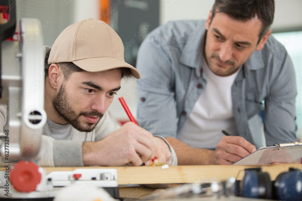 skilled carpenter and apprentice in woodworking studio skilled carpenter and apprentice in woodworking studio