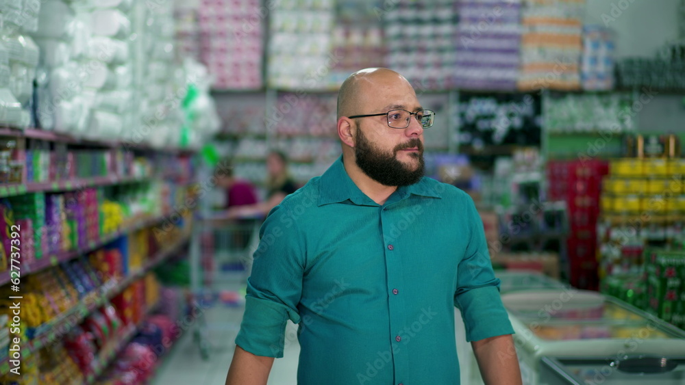 One Brazilian man shopping at grocery store. Shopper browsing products, walking through Supermarket aisle, depicting consumer lifestyle and shopping habbits One Brazilian man shopping at grocery store. Shopper browsing products, walking through Supermarket aisle, depicting consumer lifestyle and shopping habbits