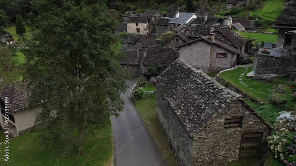 Aerial video of a man with a red coat walking in Cevio, Switzerland Aerial video of a man with a red coat walking in Cevio, Switzerland
