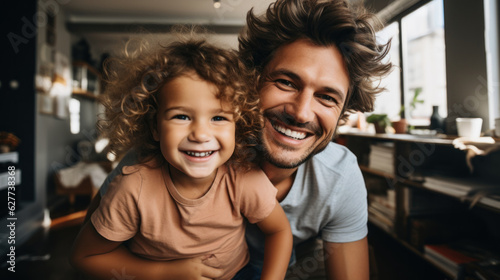 Portrait of a smiling young father and his little daughter at home.