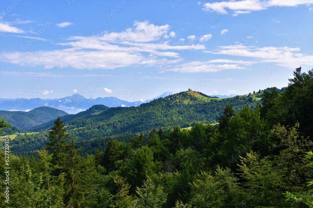 Sv. Jakob forest covered hill in Gorenjska, Slovenia and Storzic mountain behind