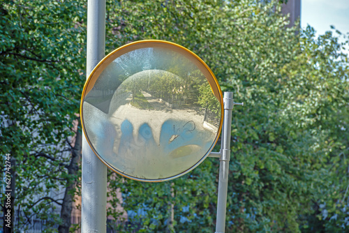 Hemispherical mirror at the exit from the parking lot on a summer day photo