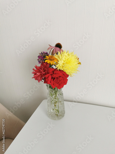 Bright bouquet of flowers on the table in a glass vase.
