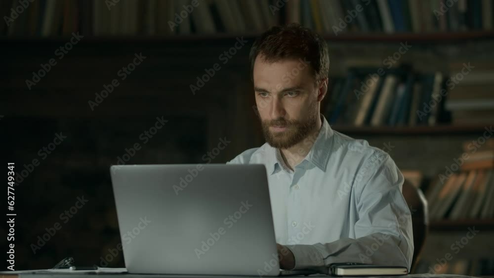 Stylish young man in office with loft style. Businessman makes notes on notebook. Business idea, thinking design, mind map. Talented man work to late night Stylish young man in office with loft style. Businessman makes notes on notebook. Business idea, thinking design, mind map. Talented man work to late night