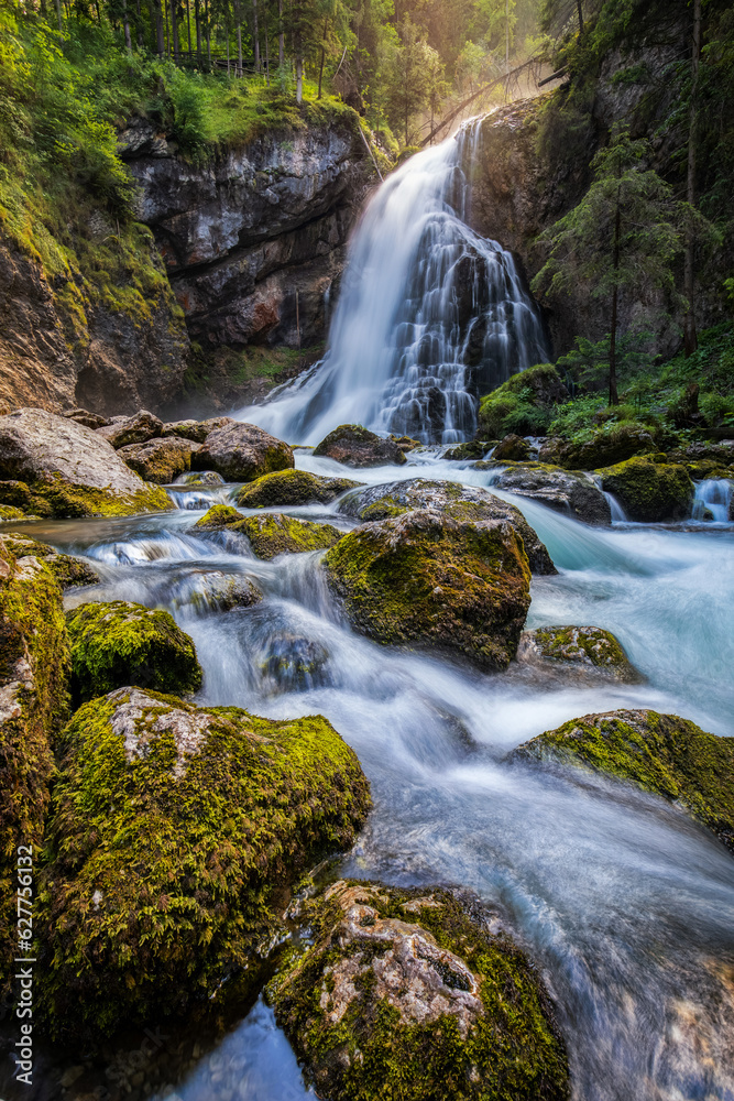 Gollinger Waterfall in Golling an der Salzach near Salzburg, Austria. Gollinger Wasserfall with mossy rocks and green trees, Golling, Salzburger Land, Austria.