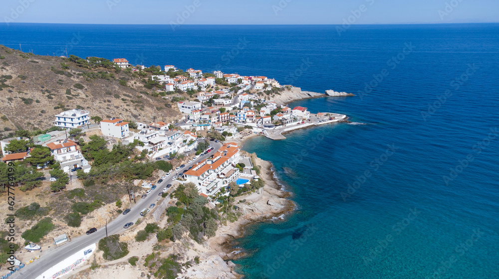 Lovely greek fisher town of Armenistis in a quiet summer morning. Port with local beach in transparent clear water at Ikaria, Greece