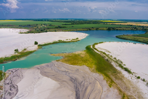 Top view of flooded quarries with white quartz sand. Beautiful artificial lakes with blue water