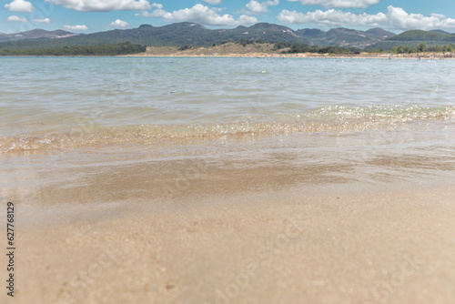 Golden sand and crystal clear sea water on the beach. Seascape, summer background.