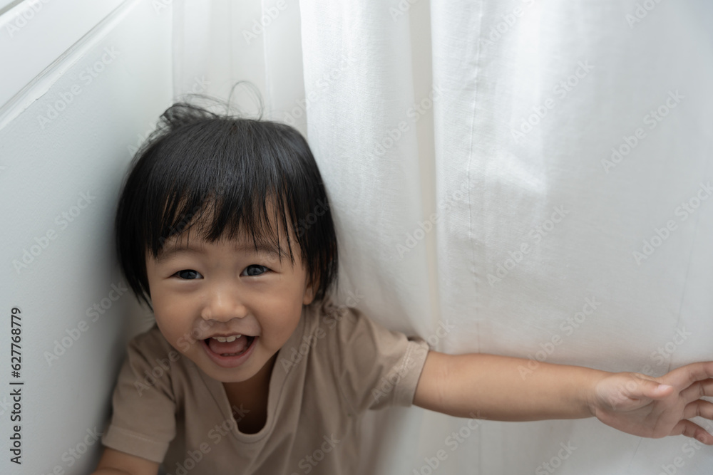 little asian children kid , playing hide and seek standing next a wall house, Adorable child having fun in the home. happy family have fun with kids, activity, learning little asian children kid , playing hide and seek standing next a wall house, Adorable child having fun in the home. happy family have fun with kids, activity, learning